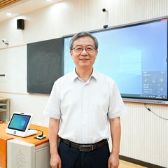 成都某教育局信息中心负责人王主任，戴着眼镜的中年男性，背景为智慧教室环境